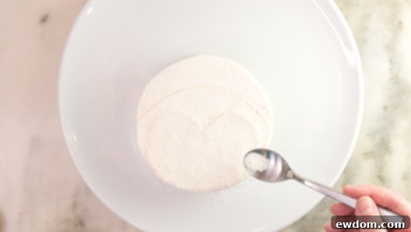 Tuxedo Treat 9 Applying white nonpareils to penguin cake face