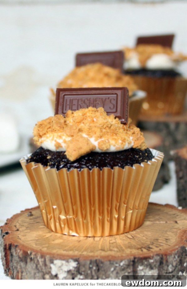 S'mores Cupcakes - easy s'more inspired cupcake recipe with chocolate cupcakes, marshmallow frosting, graham cracker crumbs and a hunk of milk chocolate | by Lauren Kapeluck for TheCakeBlog.com