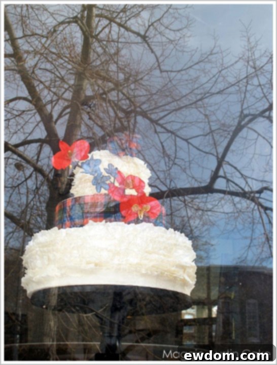 Maggie Austin's Scottish Plaid and Ruffles Christmas Cake displayed in a shop window, an irresistible sight for passersby