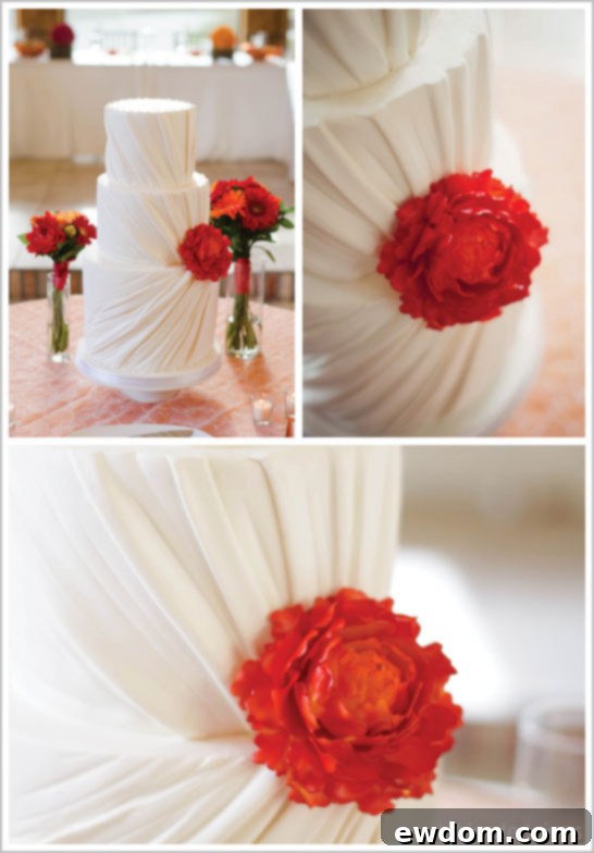 Stunning Ruched Wedding Cake with Vibrant Orange Sugar Flower as Focal Point